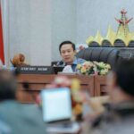 Pemprov Lampung Sinergikan DBH dan TMMD untuk Percepat Pembangunan Jalan Desa Upaya tersebut dibahas dalam Rapat Koordinasi Program Desaku Maju yang digelar di Ruang Rapat Utama Kantor Gubernur Lampung, Jumat (14/8/2026). Rakor dipimpin Sekretaris Daerah Provinsi Lampung Marindo Kurniawan dan dihadiri para Sekretaris Daerah Kabupaten/Kota se-Provinsi Lampung. Marindo mengatakan, Program Desaku Maju merupakan bagian dari upaya pemerintah dalam mendorong pembangunan sekaligus pemberdayaan masyarakat desa. Salah satu fokus program tersebut adalah pembangunan infrastruktur jalan desa yang akan diperkuat melalui kolaborasi pemerintah daerah dan TNI. "Program ini kita dorong melalui kolaborasi pemerintah provinsi, pemerintah kabupaten/kota dan TNI, terutama untuk mempercepat pembangunan jalan desa," ujar Marindo. Menurutnya, sinergi tersebut menjadi tindak lanjut komitmen bersama pemerintah daerah dan jajaran TNI dalam mendukung pembangunan infrastruktur yang menjadi kebutuhan masyarakat. Dalam skema tersebut, pemerintah kabupaten/kota diharapkan dapat memberikan dukungan melalui pengalokasian Dana Bagi Hasil (DBH). Anggaran tersebut diarahkan untuk menghasilkan pembangunan yang manfaatnya dapat dirasakan langsung oleh masyarakat. "Yang ingin kita hadirkan adalah rasa di masyarakat bahwa DBH yang disalurkan benar-benar menghasilkan pembangunan dan manfaat nyata, khususnya untuk jalan desa," jelasnya. Marindo menegaskan, pemanfaatan DBH perlu memiliki keterkaitan yang jelas dengan hasil pembangunan di lapangan. Karena itu, pembangunan jalan desa melalui Program Desaku Maju akan disinergikan dengan TMMD maupun Karya Bakti TNI sebagai salah satu opsi untuk mempercepat pelaksanaan kegiatan. Besaran anggaran maupun jumlah ruas jalan yang ditangani tidak harus sama di setiap kabupaten/kota. Penentuan alokasi akan disesuaikan dengan kebutuhan, kondisi wilayah, dan kemampuan masing-masing daerah. "Setiap desa memiliki kondisi dan kebutuhan jalan yang berbeda. Karena itu, alokasi anggaran dapat disesuaikan dengan kebutuhan di masing-masing daerah," katanya. Dalam rakor tersebut juga dibahas pentingnya keseragaman mekanisme pelaksanaan Program Desaku Maju di seluruh kabupaten/kota. Formulasi teknis, termasuk mekanisme penganggaran, pelaksanaan kegiatan, serta bentuk kolaborasi dengan TNI, akan diperkuat melalui nota kesepahaman (MoU). Marindo juga meminta dukungan Badan Pengawasan Keuangan dan Pembangunan (BPKP) untuk memastikan mekanisme pengalokasian dan pelaksanaan anggaran sesuai dengan ketentuan. Hasil pembahasan bersama BPKP selanjutnya akan menjadi bahan dalam penyusunan dan penyempurnaan MoU agar pelaksanaan program berjalan secara terarah, transparan, dan akuntabel. Melalui sinergi DBH dan TMMD, Pemprov Lampung bersama pemerintah kabupaten/kota dan TNI berupaya mempercepat pembangunan jalan desa sekaligus memastikan anggaran daerah memberikan manfaat nyata bagi masyarakat. Peningkatan infrastruktur jalan diharapkan dapat memperkuat konektivitas antarwilayah, memperlancar mobilitas masyarakat dan distribusi hasil pertanian, serta mendukung aktivitas ekonomi dan peningkatan kesejahteraan masyarakat desa di Lampung. **(*** **)**