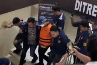 Dugaan Korupsi 387 Honorer Metro, Welly Adiwantra Digiring ke Tahanan Polda **LAMPUNG —** Rompi tahanan berwarna kuning melekat di tubuh Welly Adiwantra. Mengenakan masker dan topi, Sekretaris Daerah (Sekda) Lampung Tengah itu digiring menuju ruang tahanan Polda Lampung, Jumat (18/9/2026). Langkah Welly menuju tahanan menjadi penanda babak baru kasus dugaan korupsi rekrutmen tenaga honorer di lingkungan Pemerintah Kota (Pemkot) Metro. Sebelumnya, Welly menjalani pemeriksaan penyidik Subdit III Tipikor Ditreskrimsus Polda Lampung sejak pukul 08.00 WIB hingga 17.19 WIB. Setelah pemeriksaan rampung, statusnya berujung pada penahanan. Direktur Reserse Kriminal Khusus (Dirreskrimsus) Polda Lampung, Kombes Pol Heri Rusyaman, membenarkan pemeriksaan terhadap Welly. “Iya, benar hari ini menjalani pemeriksaan,” ujar Heri. Perkara tersebut berkaitan dengan dugaan korupsi rekrutmen tenaga honorer ketika Welly menjabat sebagai Kepala Badan Kepegawaian dan Pengembangan Sumber Daya Manusia (BKPSDM) Kota Metro. Kasubdit III Tipikor Ditreskrimsus Polda Lampung, AKBP Donny Hendridunand, mengatakan penyidik menduga terjadi rekrutmen tenaga honorer atau tenaga kontrak pada tahun anggaran 2024–2025 yang tidak sesuai dengan ketentuan perundang-undangan. “Total ada 387 honorer, tenaga kontrak. Sejak tahun 2023 itu dilarang, karena ada penataan,” kata Donny. Rekrutmen tersebut berkaitan dengan kebijakan penataan tenaga non-ASN sebagaimana diatur dalam Undang-Undang Nomor 20 Tahun 2023 tentang Aparatur Sipil Negara (ASN). Dugaan penyimpangan itu kemudian berujung pada kerugian keuangan negara. Berdasarkan hasil audit Badan Pengawasan Keuangan dan Pembangunan (BPKP) Perwakilan Lampung, kerugian negara dalam perkara tersebut mencapai **Rp7,38 miliar**. Angka itu menjadi salah satu titik penting dalam perkara yang kini menjerat Welly. Sebab, rekrutmen ratusan tenaga kontrak tersebut diduga berdampak pada penggunaan anggaran daerah. ### Dijerat Pasal Korupsi Polda Lampung masih memproses berkas perkara Welly. Penyidik juga telah menindaklanjuti hasil penelitian dari jaksa penuntut umum (JPU). Welly dijerat Pasal 2 ayat (1) atau Pasal 3 juncto Pasal 18 Undang-Undang Nomor 31 Tahun 1999 tentang Pemberantasan Tindak Pidana Korupsi. Penyidik juga menerapkan Pasal 603 atau subsider Pasal 604 Undang-Undang Nomor 1 Tahun 2023 tentang Kitab Undang-Undang Hukum Pidana (KUHP). Penahanan Welly menjadi perkembangan terbaru dalam perkara dugaan korupsi rekrutmen 387 tenaga honorer di lingkungan Pemkot Metro. Dari ruang pemeriksaan, Welly kini berada di balik pintu tahanan Polda Lampung, sementara proses hukum terhadap perkara yang disebut menimbulkan kerugian negara Rp7,38 miliar itu masih berjalan. *(ela)*